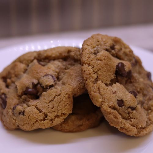 close up of a plate of three of the best einkorn brown butter chocolate chip cookies stacked