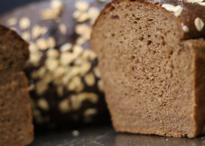 close up of sliced pumpernickel loaf with oats made with fresh milled rye flour