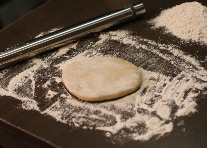 metal rolling pin with fresh milled flour on the table, getting ready to roll out kamut pasta dough