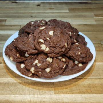 A plate full of a mounded pile of Chewy Double Chocolate Cookies with White Chips, all made with fresh milled flour