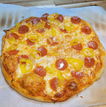a photo of a pepperoni & banana pepper homemade pizza baked with bubbly crust, dough made with fresh milled flour