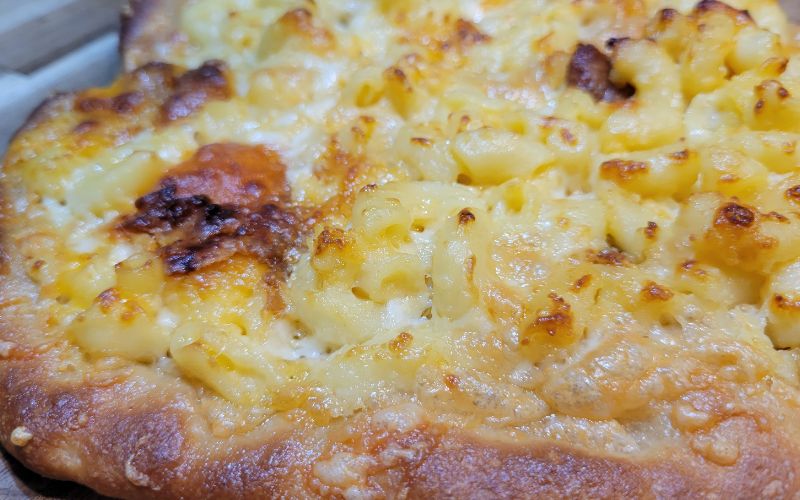 close up of a macaroni & cheese pizza