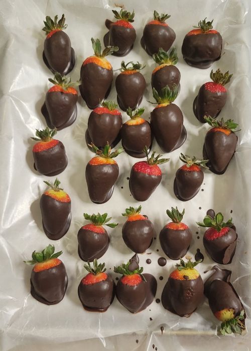 tray of fresh strawberries dipped in dark chocolate