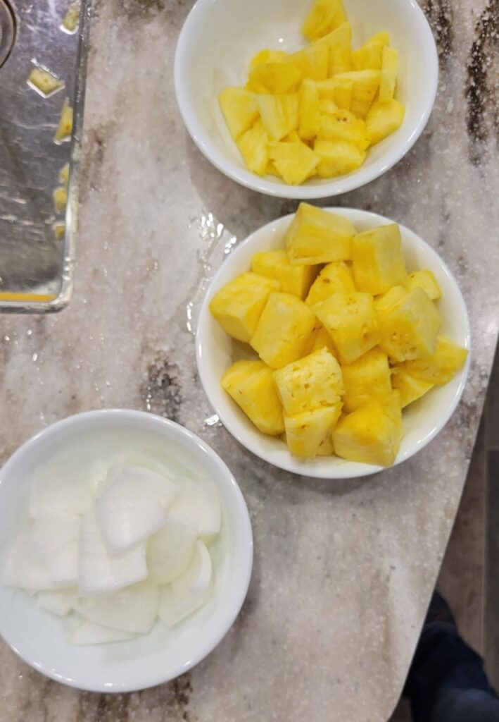 bowls filled with cubed pineapple and onion