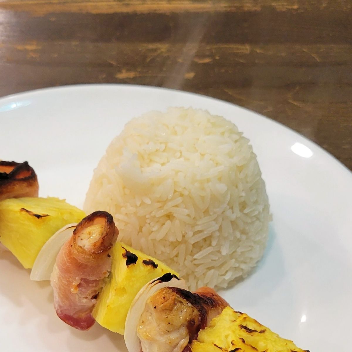the perfect jasmine rice from the pressure cooker sitting next to a skewer.
