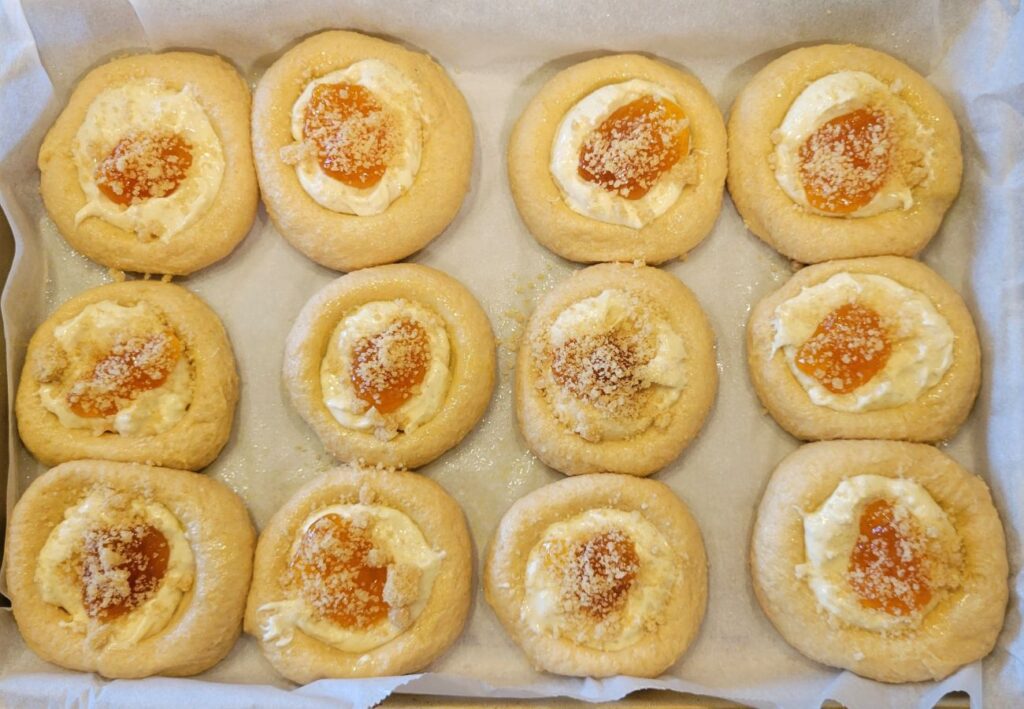 a tray of apricot kolache pastries rising