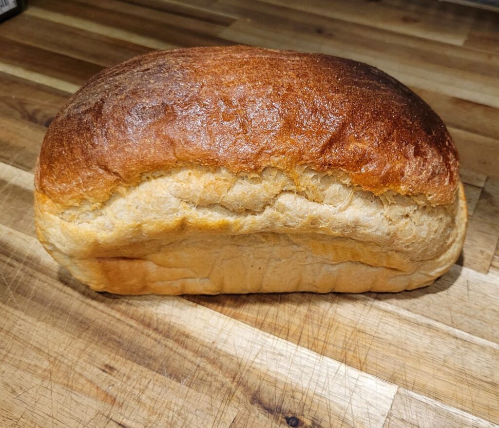 a homemade loaf of white sandwich bread made with whole wheat whole grain fresh milled flour