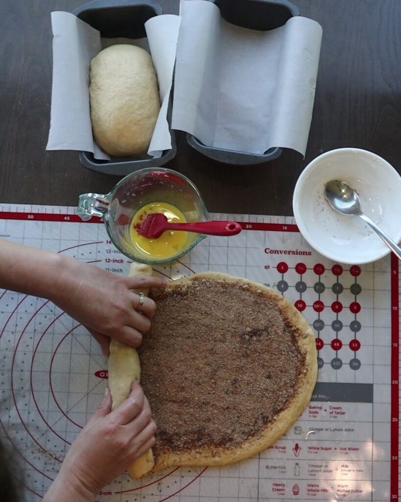 hands rolling up the fresh milled flour cinnamon swirl bread dough