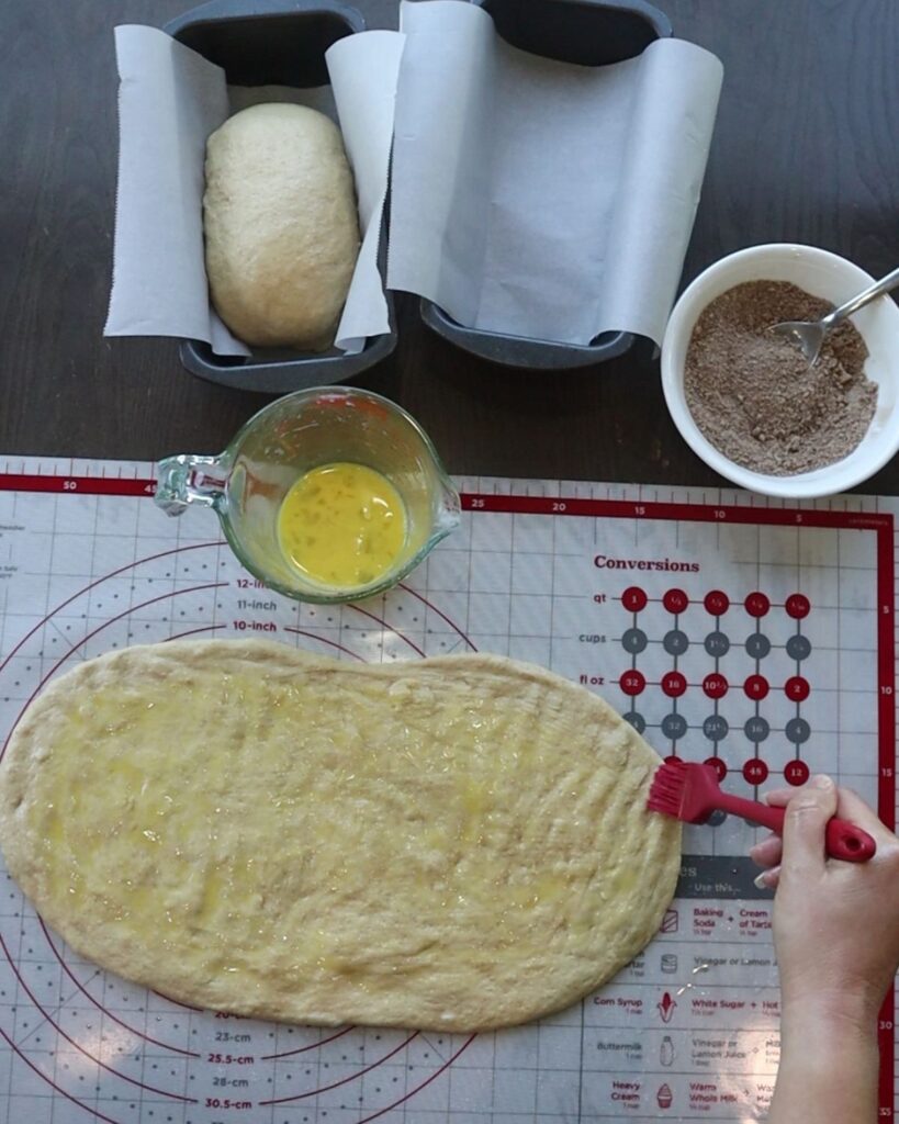 hands use pastry brush to apply egg before the filling, not butter