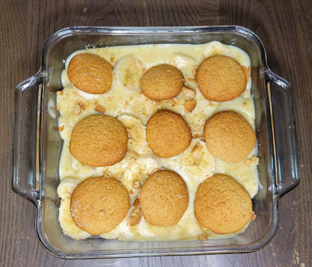a 8x8 glass baking dish with microwave vanilla pudding with fresh bananas and topped with homemade vanilla wafers