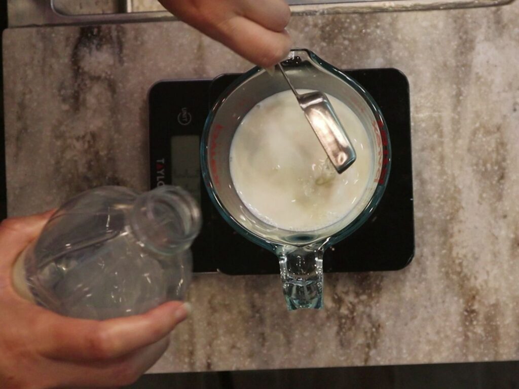 hand pouring vinegar into whole milk to make a buttermilk substitute