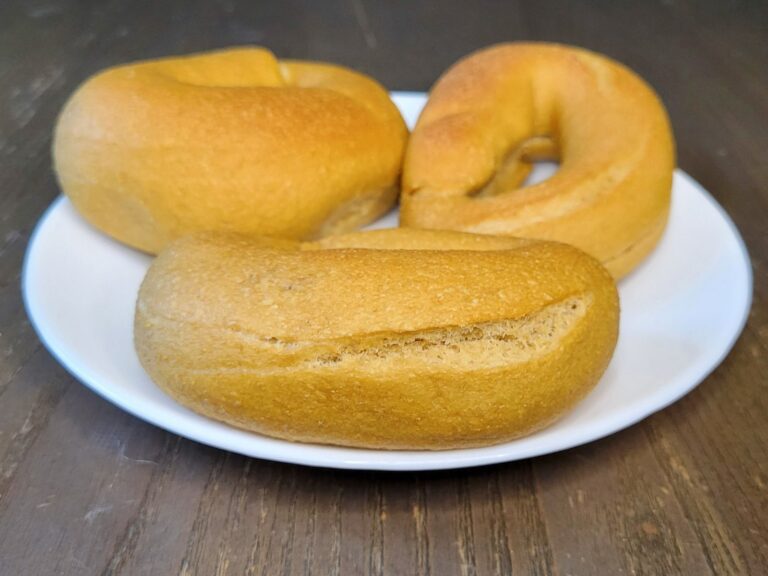 three NY Style Bagels Made with fresh milled flour unsliced, baked golden brown on a white plate