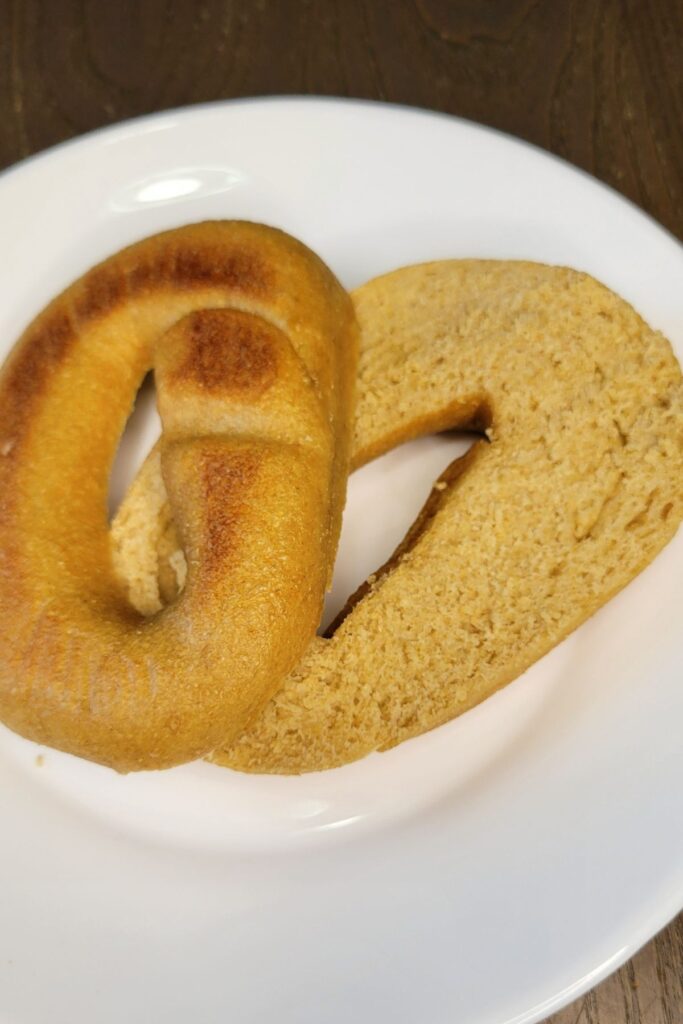 a fresh milled flour bagel sliced in half with the bottom facing up so you can see the golden brown bottom, and the dense bagel crumb on the inside.