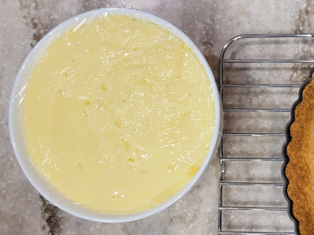 a bowl of fresh milled flour pastry cream covered by plastic wrap