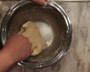kneading the fresh milled flour naan dough in a bowl