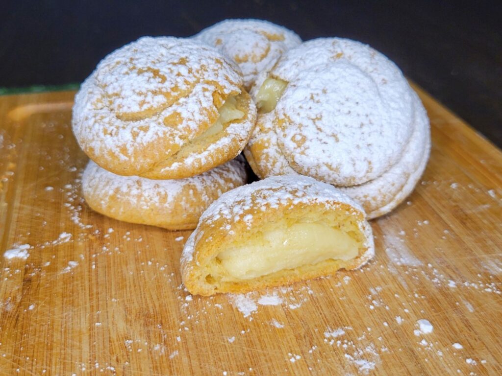 homemade cream puffs made with fresh milled flour dusted in powder sugar and filled with pastry cream made from scratch