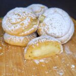homemade cream puffs made with fresh milled flour dusted in powder sugar and filled with pastry cream made from scratch