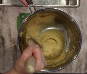 hand stirring choux batter is ready to pipe