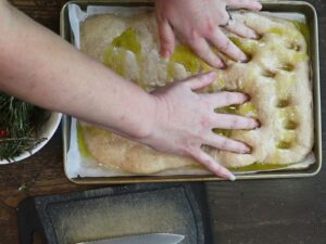 hands using fingers to press the dough