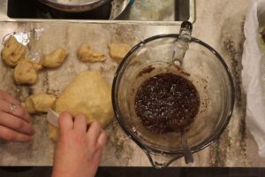 cutting the monkey bread dough pieces into the cinnamon sugar mixture