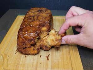 hand pulling a piece of pull apart monkey bread fresh milled flour