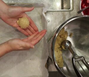 hands rolling the cookie dough into balls