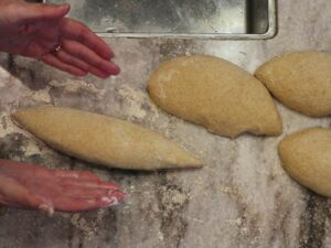 hands shaping the sourdough baguettes made with fresh milled flour