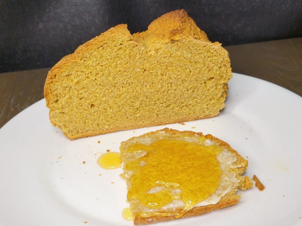 sliced irish soda bread made with fresh milled flour with butter and honey on the slice