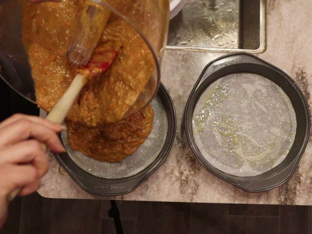 pouring out half the batter into each lined and oiled pan