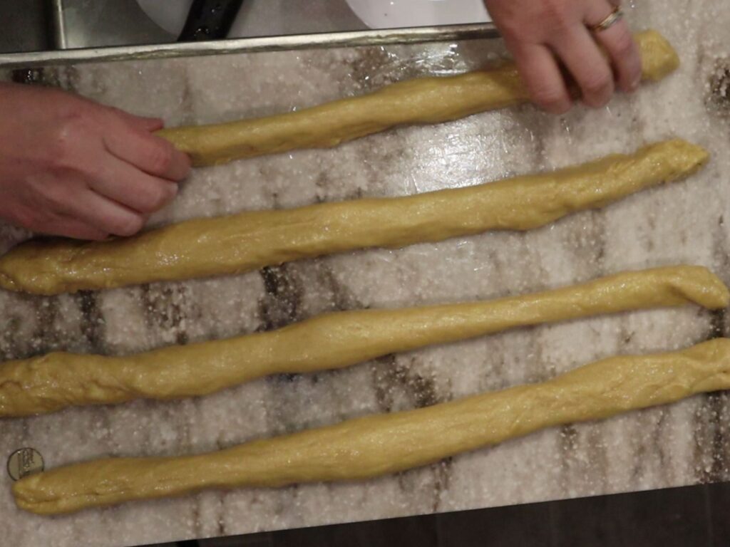 rolling out four strands of fresh milled flour challah dough