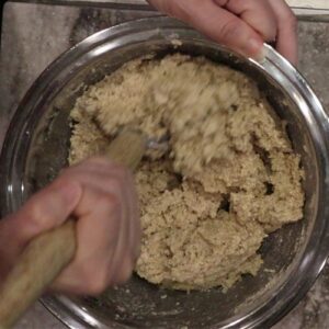 hand using a danish dough whisk to stir fresh milled flour soda bread ingredients together