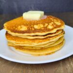 a stack of Fresh Milled Flour Pancakes steaming and topped with melting butter