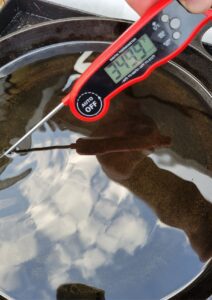 checking the temperature of the oil with a digital thermometer