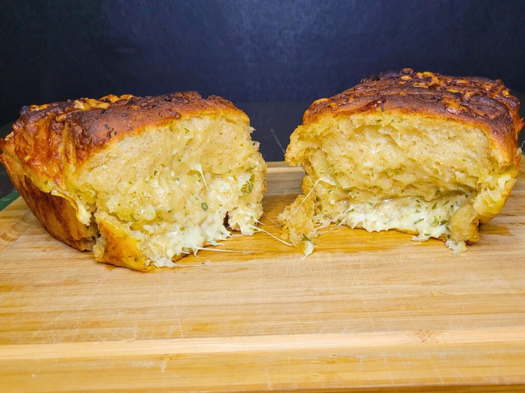 cheesy garlic pull apart bread made with fresh milled flour pulled apart showing the cheese and garlic butter filling