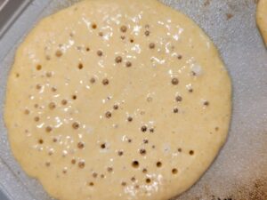 fresh milled flour pancakes ready to flip showing the bubbles on top of the batter