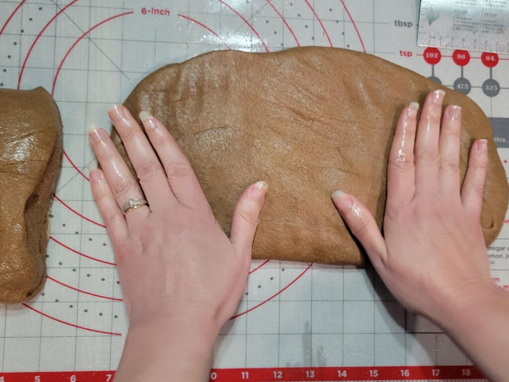 hands flattening fresh milled flour brown bread dough