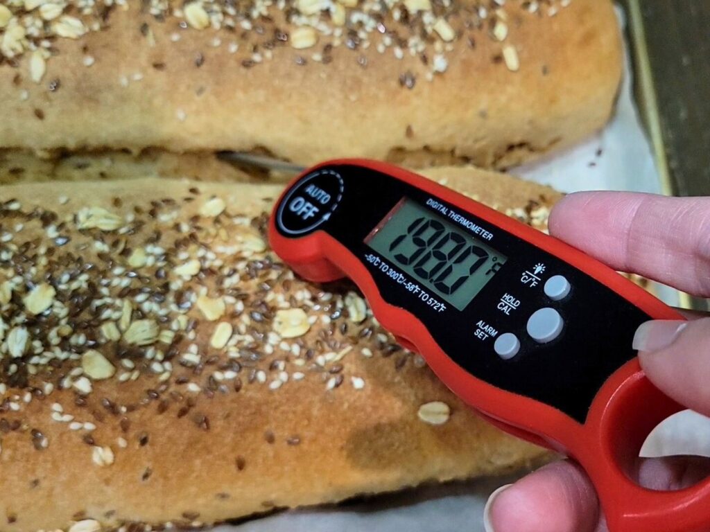 taking the temp of the center of the loaf with a digital kitchen thermometer