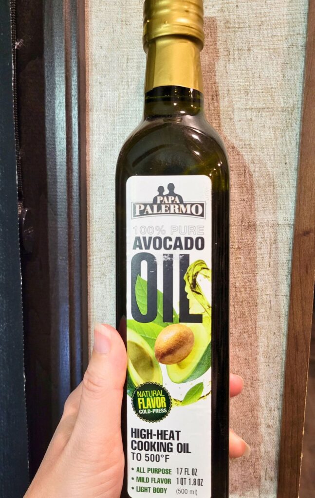 hand holding a bottle of avocado oil