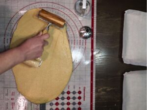 hand rolling out the dough with mini double roller