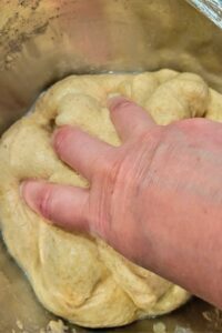 hand mixing the salt solution into the dough