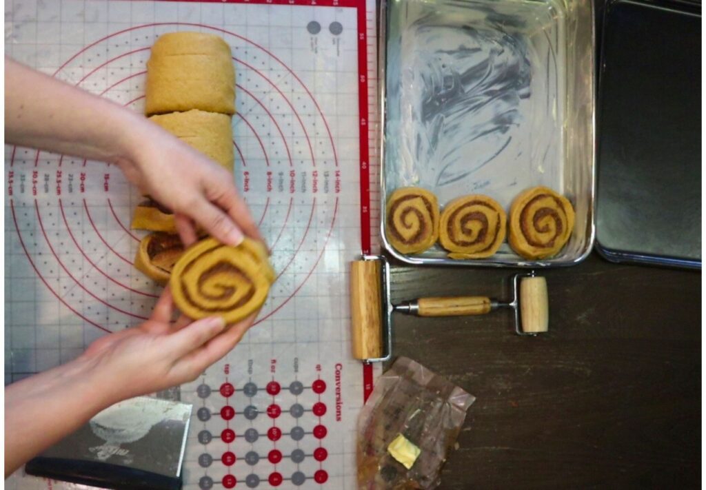 cutting the fresh milled flour pumpkin cinnamon rolls