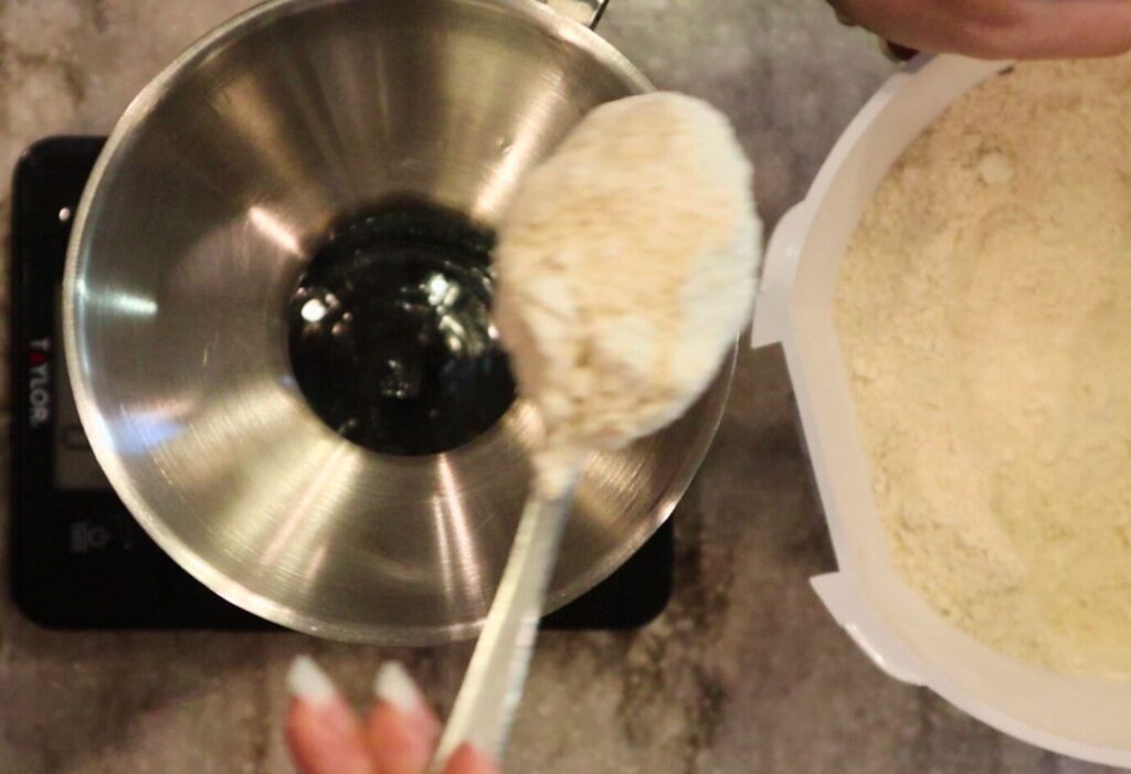 pouring soft white wheat flour into a mason jar for a homemade holiday gift