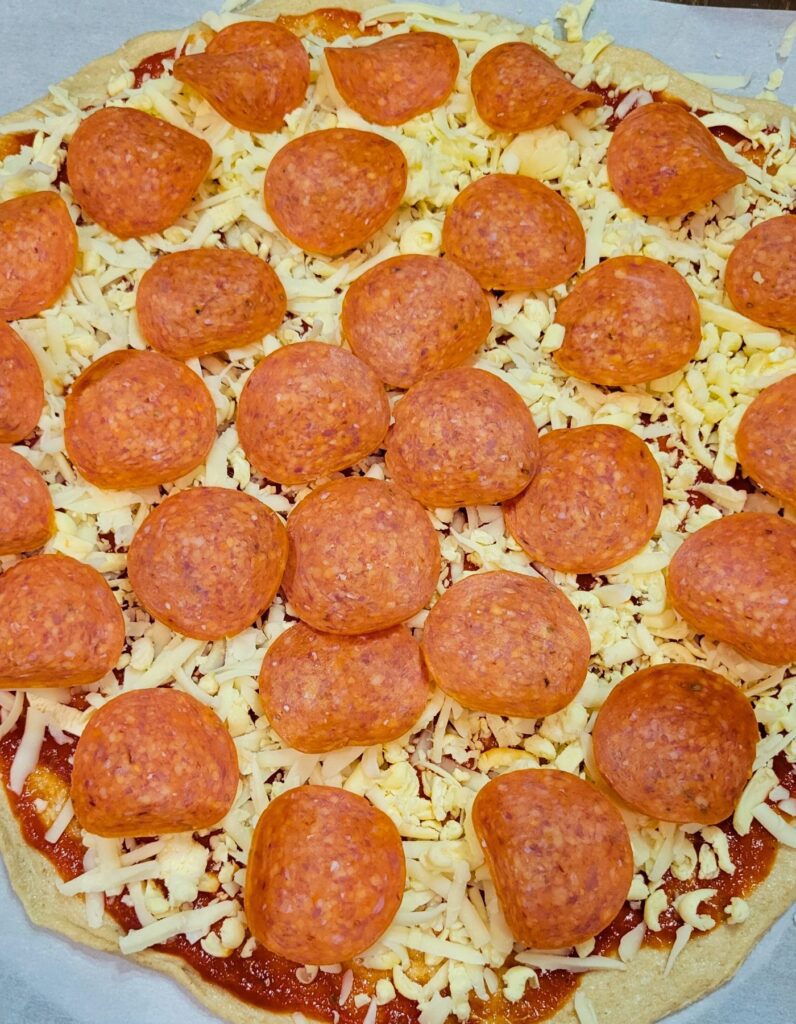 sauce, pepperoni and cheese loaded on top, and ready to bake