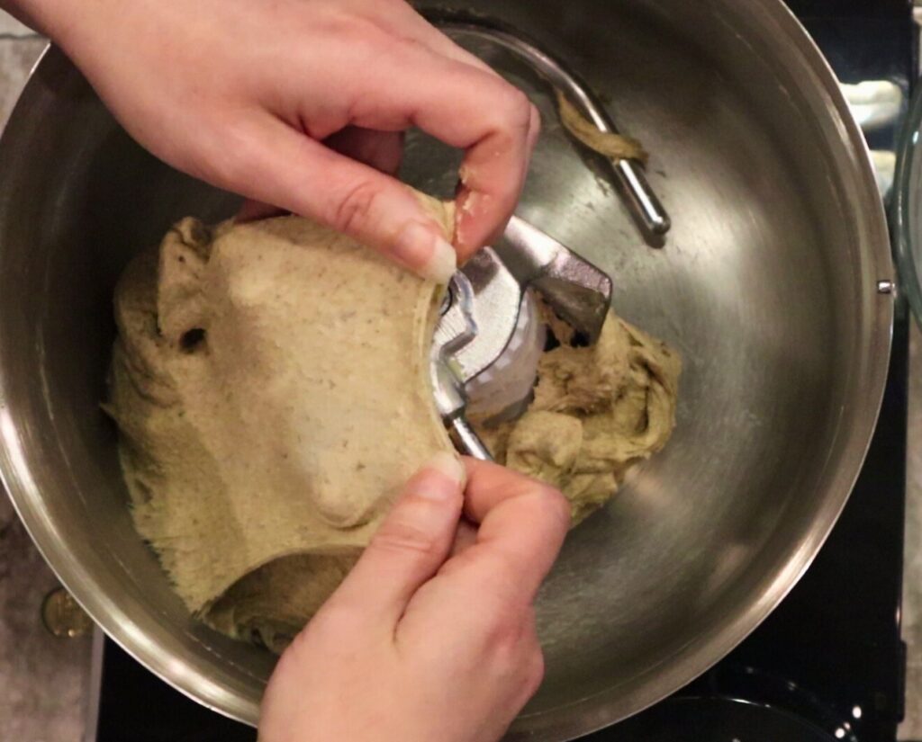 hands showing stretchy dough - a window pane for fresh milled flour rye bread