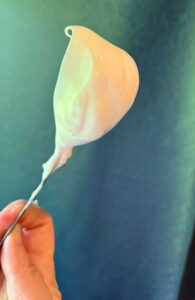 Checking the egg whites for stiff peaks with a spoon