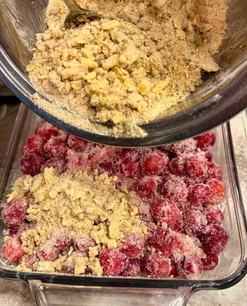 Adding the fresh milled flour crumble on top of the cherry crisp