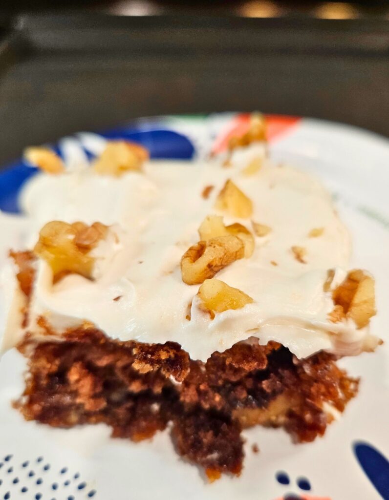 apple walnut cake slice made with fresh milled flour cream cheese frosting