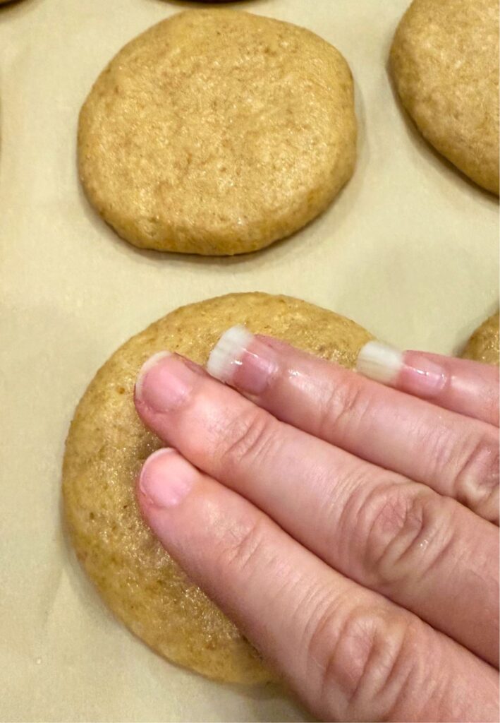 pressing down the dough balls into a disk